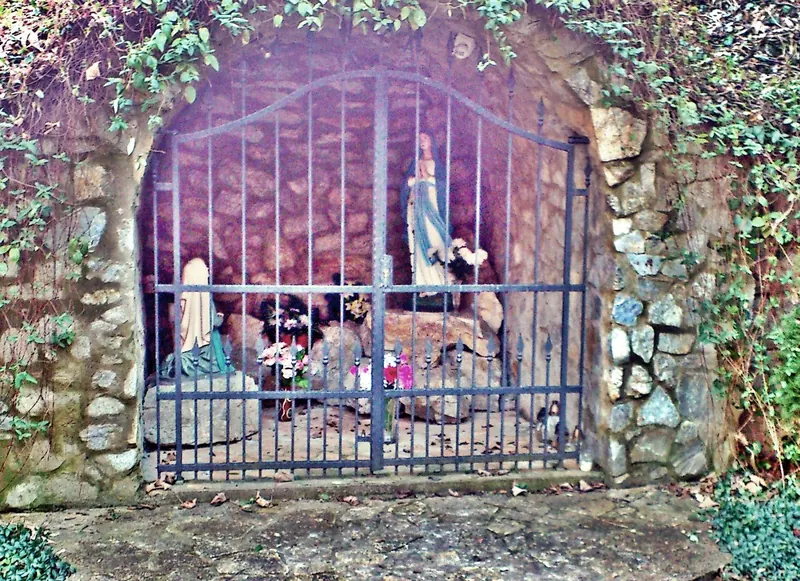 A Lourdes-i sziklabarlang a templom mellett